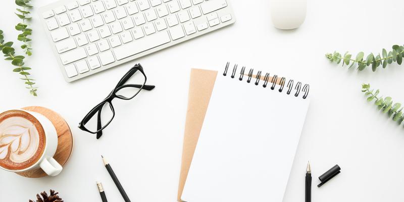 illustrative image of office supplies on a white desk