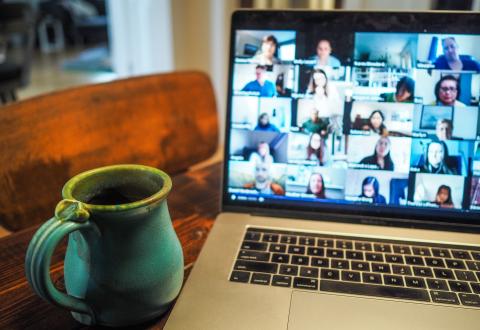 Laptop screen with faces on a Zoom call.