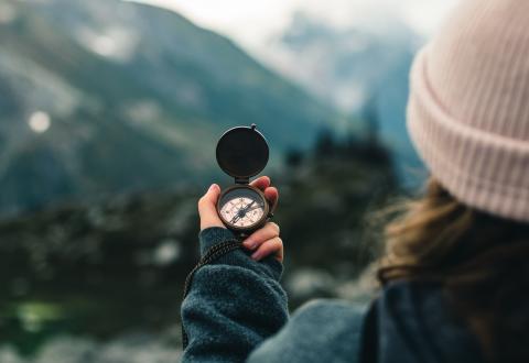 A person holding a compass in their hands. 