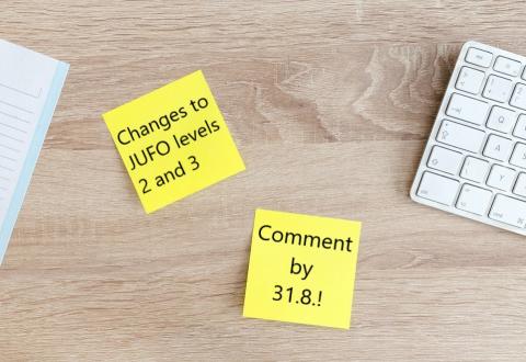 Photo of two post it notes on a desk. On the notes there is a text: "Changes to JUFO levels 2 and 3. Comment by 31.8.!".